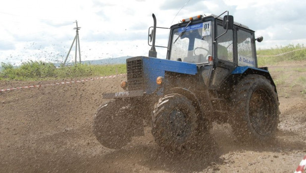 Трактор мчит по грязи.