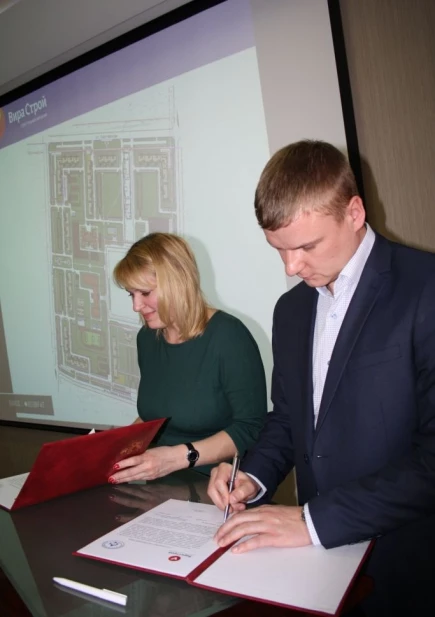 Денис Краев и Марина Ракина подписывают соглашение.