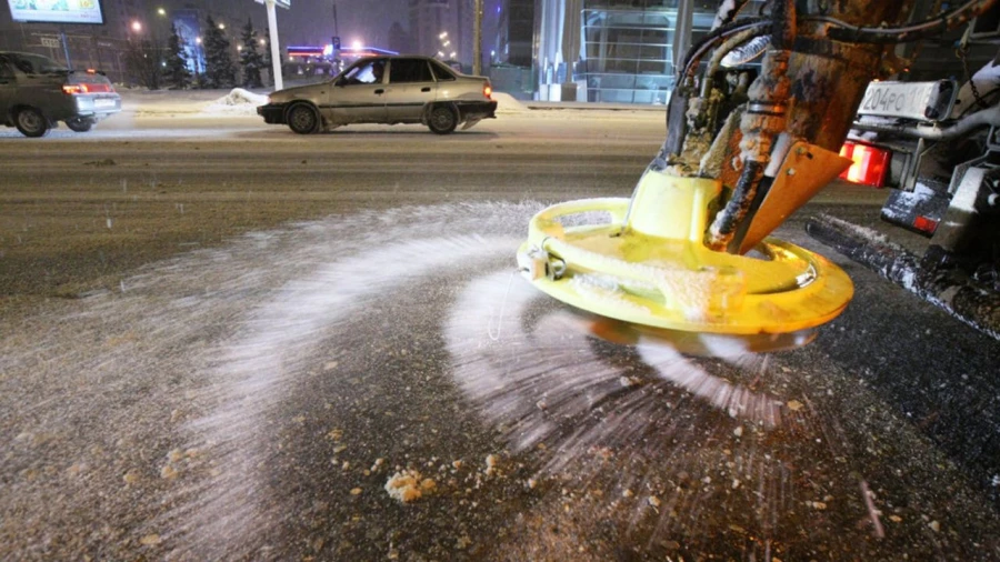Обработка дороги песчано-соляной смесью.
