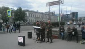 Люди в военной форме исполняют патриотические песни на улицах Барнаула.