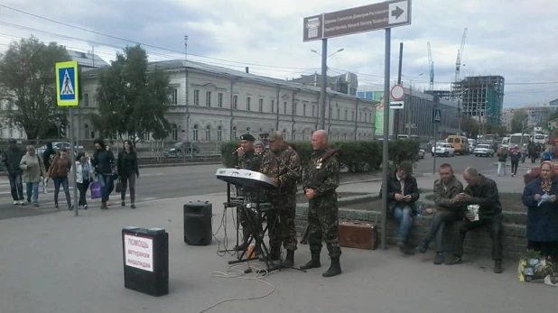 Люди в военной форме исполняют патриотические песни на улицах Барнаула.