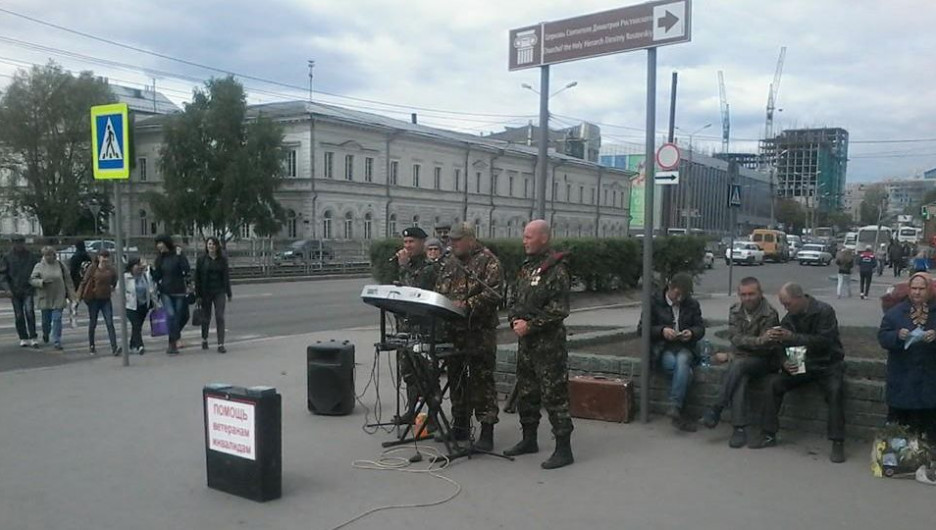 Люди в военной форме исполняют патриотические песни на улицах Барнаула.