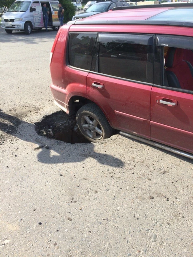 В Барнауле Nissan провалился в яму на асфальте. 27 июня 2016 года.