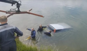 Эвакуатор достает утонувшую машину.