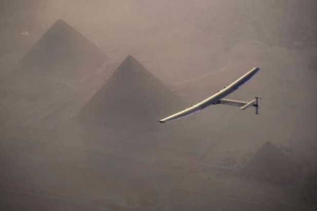 Самолёт Solar Impulse 2, движущийся только за счёт солнечной энергии, на фоне египетских пирамид