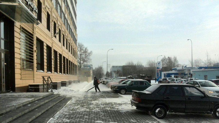 Возле администрации города чистят снег.