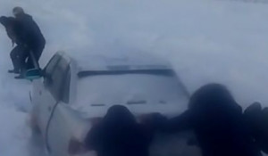 Люди вызволяют застрявшую в снегу машину в Усть-Канском районе.