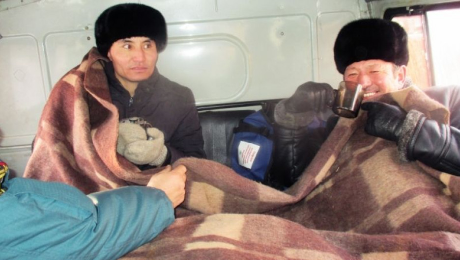 Жители Монголии отогреваются в машине МЧС.