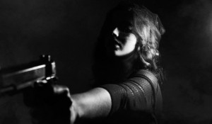 Женщина стреляет из пистолета.