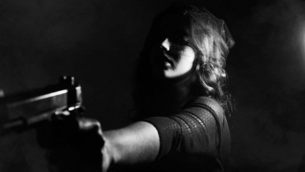 Женщина стреляет из пистолета.