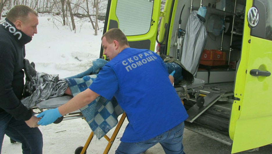 Новосибирские спасатели передают мужчину медикам.