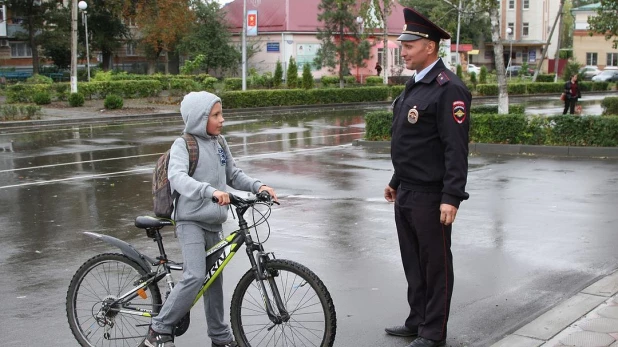 Полицейский и ребенок на велосипеде. 