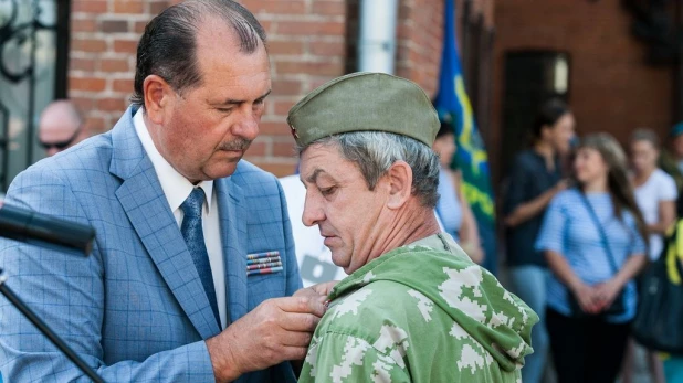 Сергей Завалихин вручает награду.