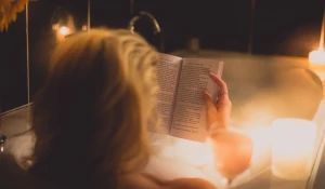Девушка в ванне читает книгу.