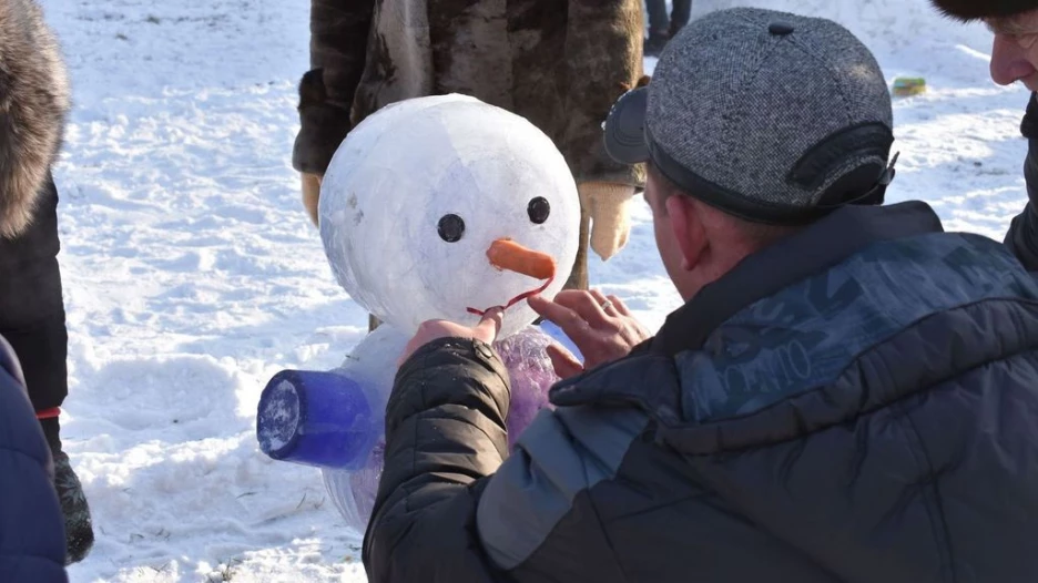 Мужчина лепит снеговика фото