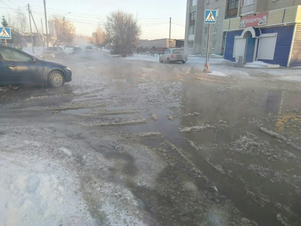 В Барнауле возле школы №51 вода затапливает дорогу. 31 января 2018 года.