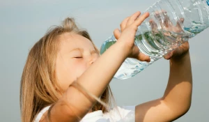 Девочка пьет воду.