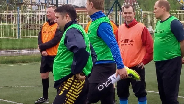 Алексей Каретников (на первом плане) играет в футбол с членами правительства.