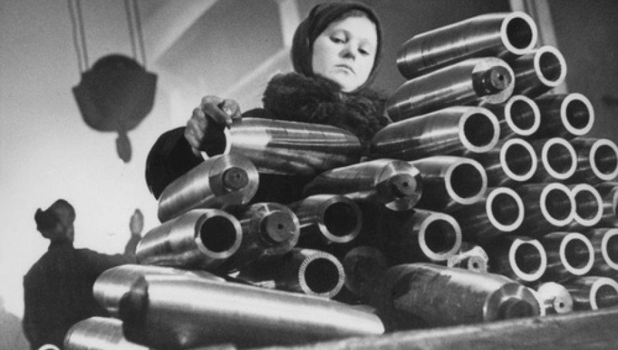 В цехе завода. Девочка укладывает болванки снарядов
(1942 год)