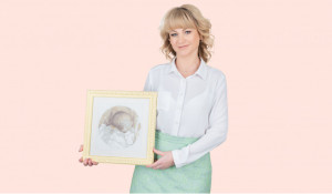 Наталья​ Воронова,​ ведущий​ репродуктолог​ «Клиники Пасман» с картиной, которую ей подарила пациентка —​ эту вышивку она сделала​ 10 лет назад​ и​ дала зарок подарить​ ее​ доктору, который сможет помочь ей​ родить ребёнка.