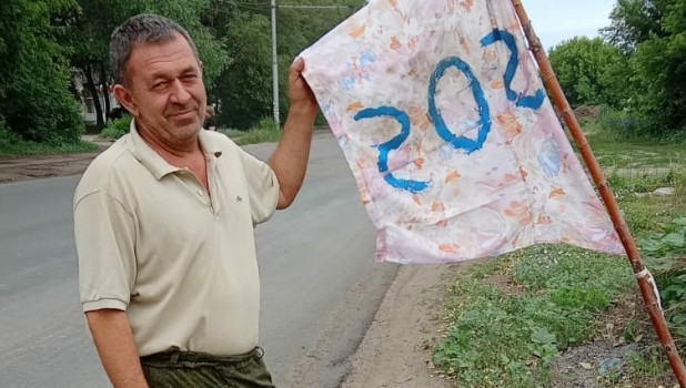 Житель Рубцовска поставил на дороге флаг SOS, чтобы автомобили не «улетали» в яму.