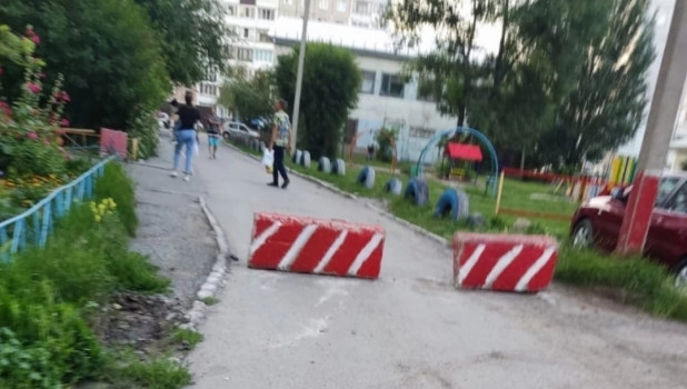 Проезд у дома на улице Попова перегородили бетонными блоками