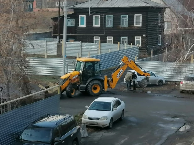 Рабочие моют ковш экскаватора из колонки в центре Барнаула.