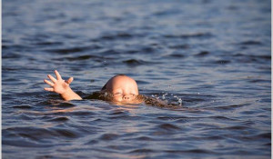Ребенок тонет в воде.