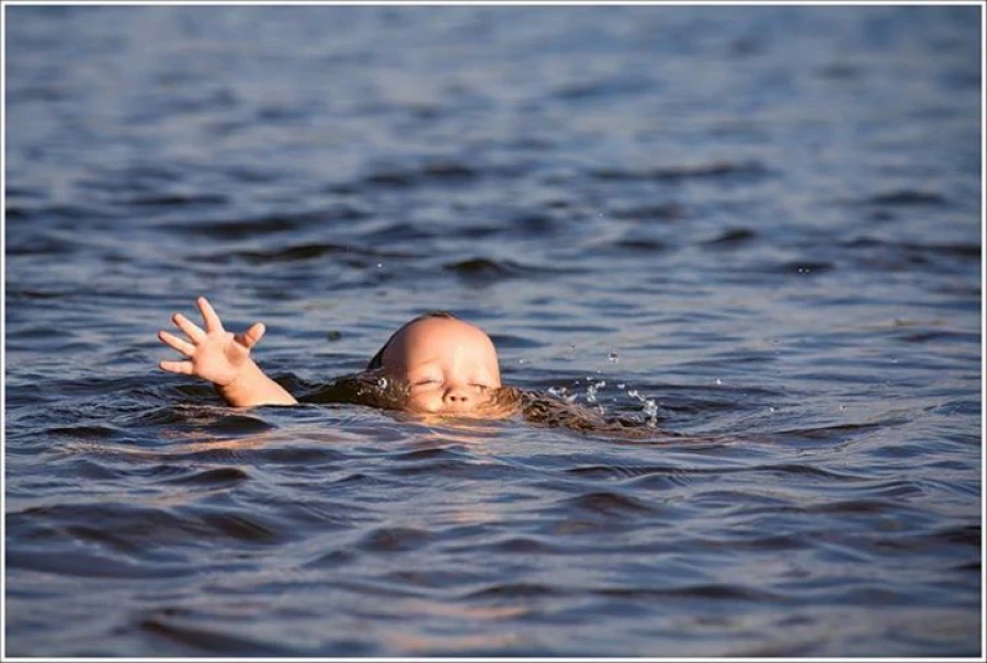 Ребенок тонет в воде.