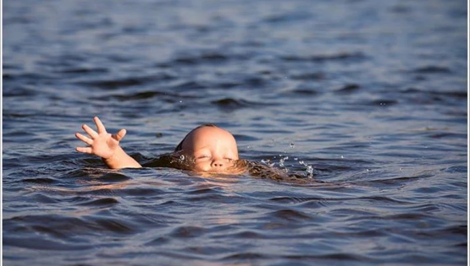 Ребенок тонет в воде.