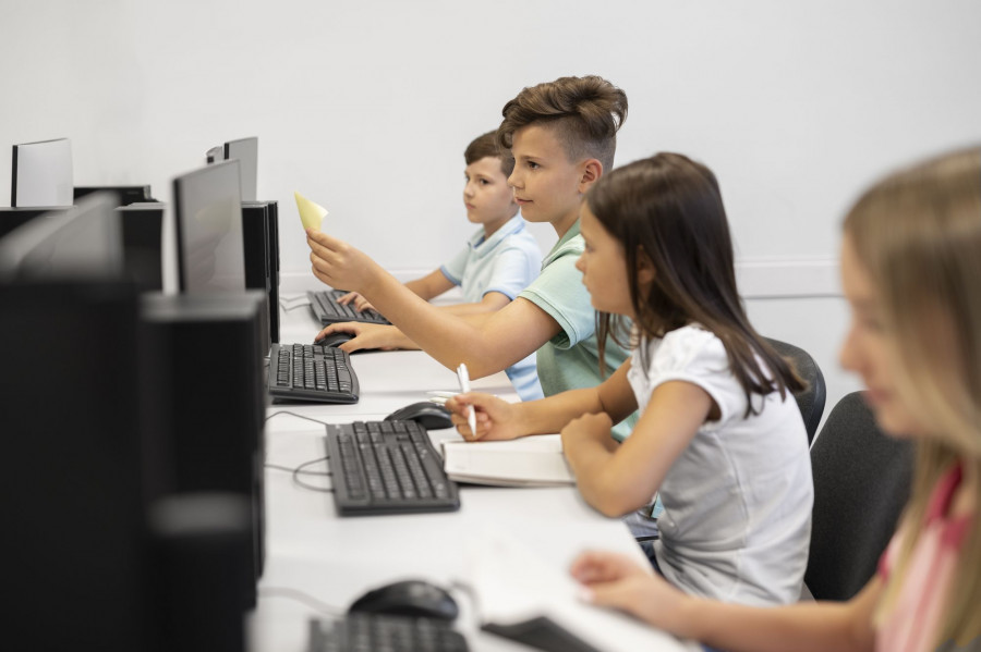 Школьники работают за компьютерами.