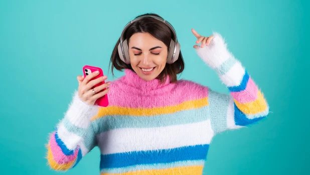 Девушка слушает музыку со смартфона.