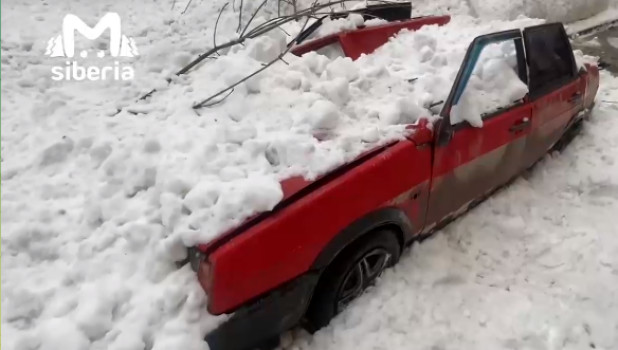 Расплющенный снегом автомобиль.