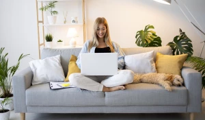 Девушка работает дома за ноутбуком.