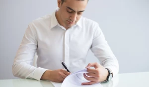 Мужчина заполняет бумаги.