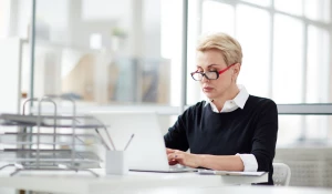 Женщина работает за ноутбуком.