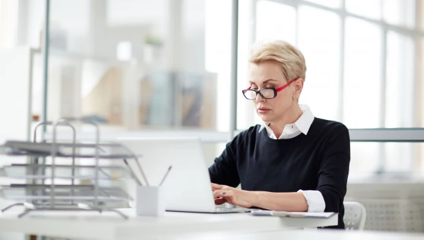 Женщина работает за ноутбуком.