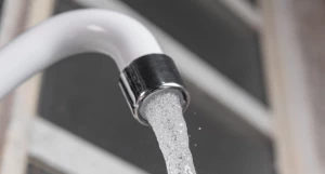 Вода течет из водопроводного крана.