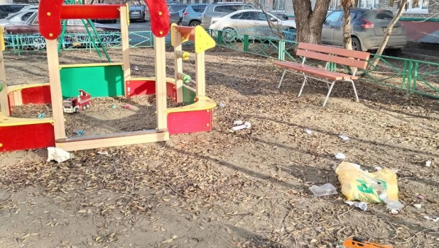 В барнаульском дворе мусор разлетается по всей детской площадке 