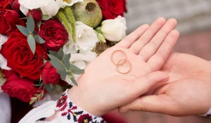 Жених и невеста держат в руках обручальные кольца.