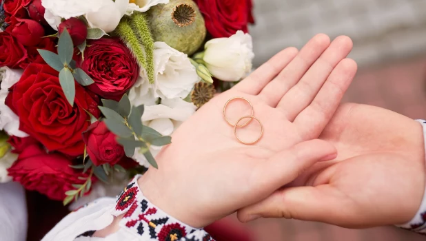Жених и невеста держат в руках обручальные кольца.