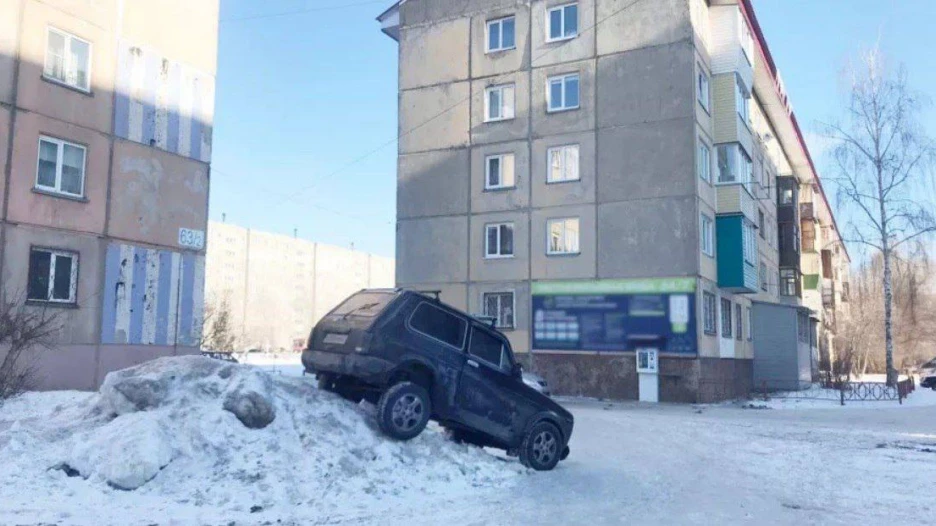 Автомобиль припарковали на снежной горе. 