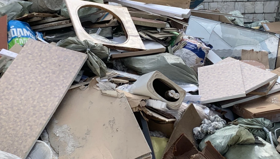 Ремонтники выкидывают строительный мусор с окон. 