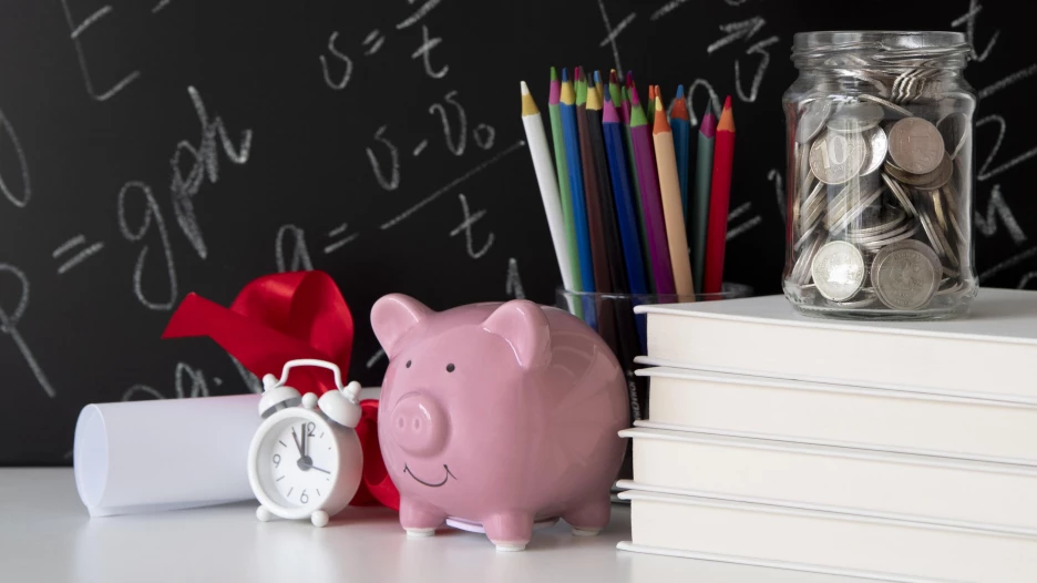 Учебные принадлежности, будильник, копилка, банка с монетами.