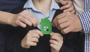 Семья держит фигурку домика.