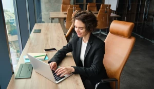 Девушка работает за ноутбуком.