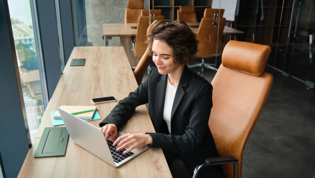 Девушка работает за ноутбуком.