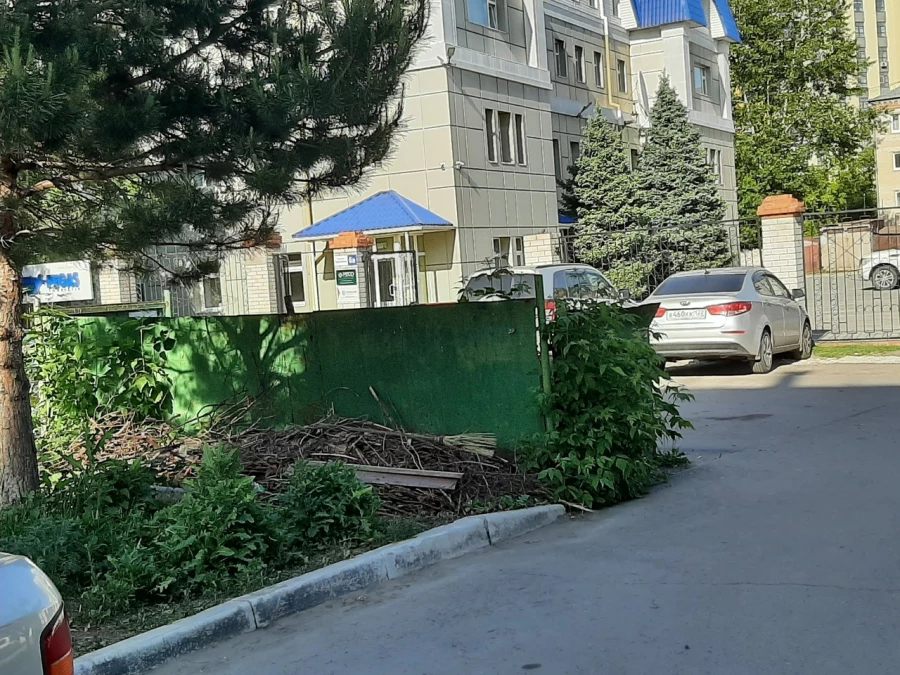 Мусорные контейнеры за ограждением.