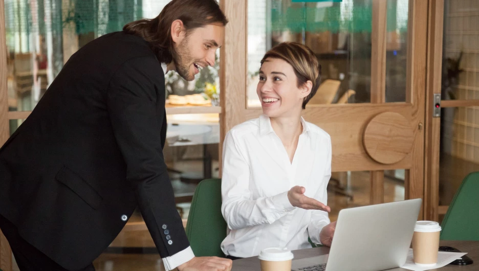 Девушка показывает мужчине интересную информацию на ноутбуке.