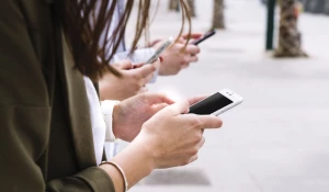 Трое человек, пользующихся смартфонами.